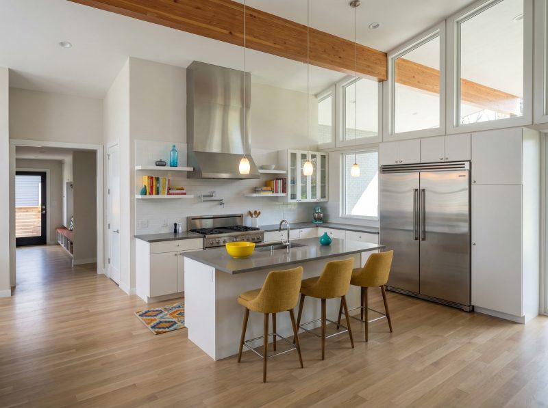 Kitchen with a white island, yellow counter stools and an exposed wood beam