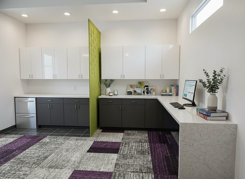 Staff workstation with a green partition, upper cabinets and a clerestory window