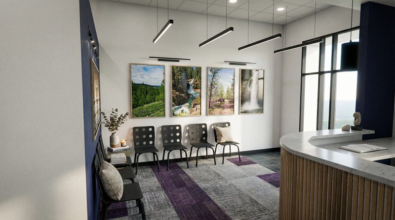Reception seating beneath framed landscape photographs, with the check-in desk at right