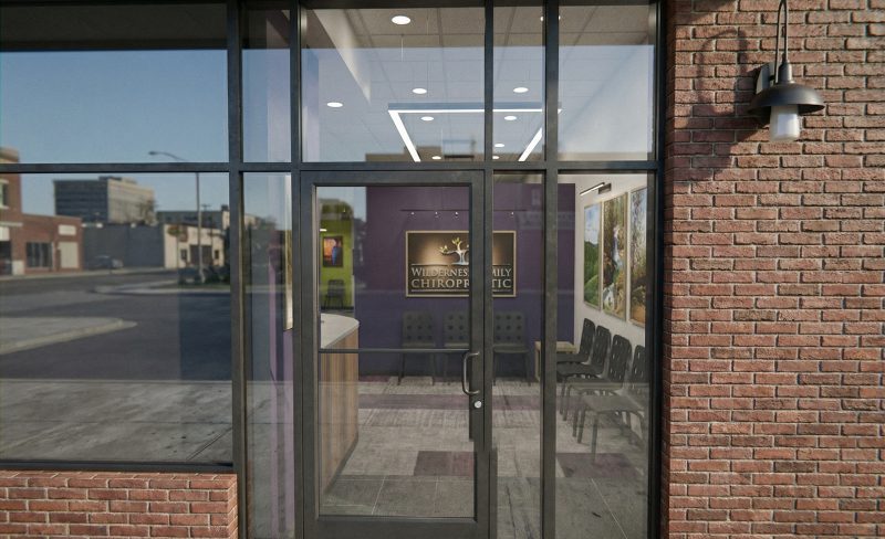 Glass entry doors set into the brick storefront at Wilderness Family Chiropractic