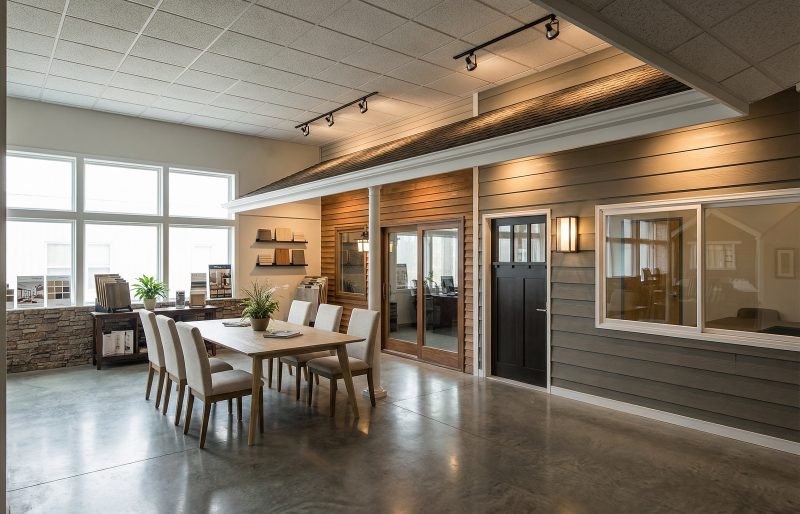 Showroom interior with a wood-sided display wall and a consultation table