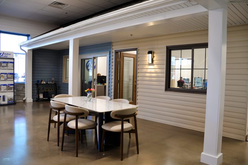 Showroom with a full-scale covered porch mockup and a consultation table