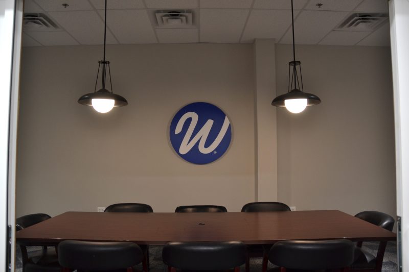Conference room with pendant lighting and the Window World logo on the end wall