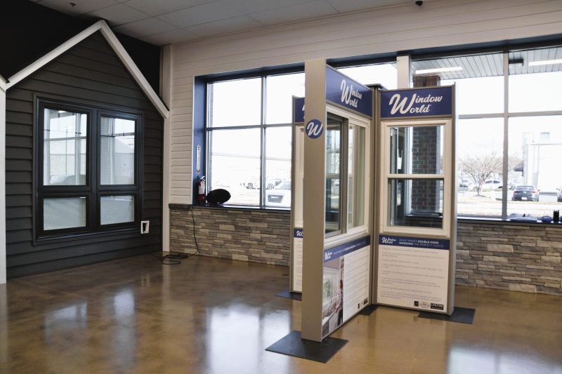 Free-standing window display in front of a full-scale house facade in the showroom