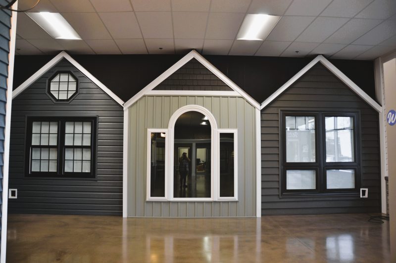 Full-scale facade mockup in dark siding, showing window and door options